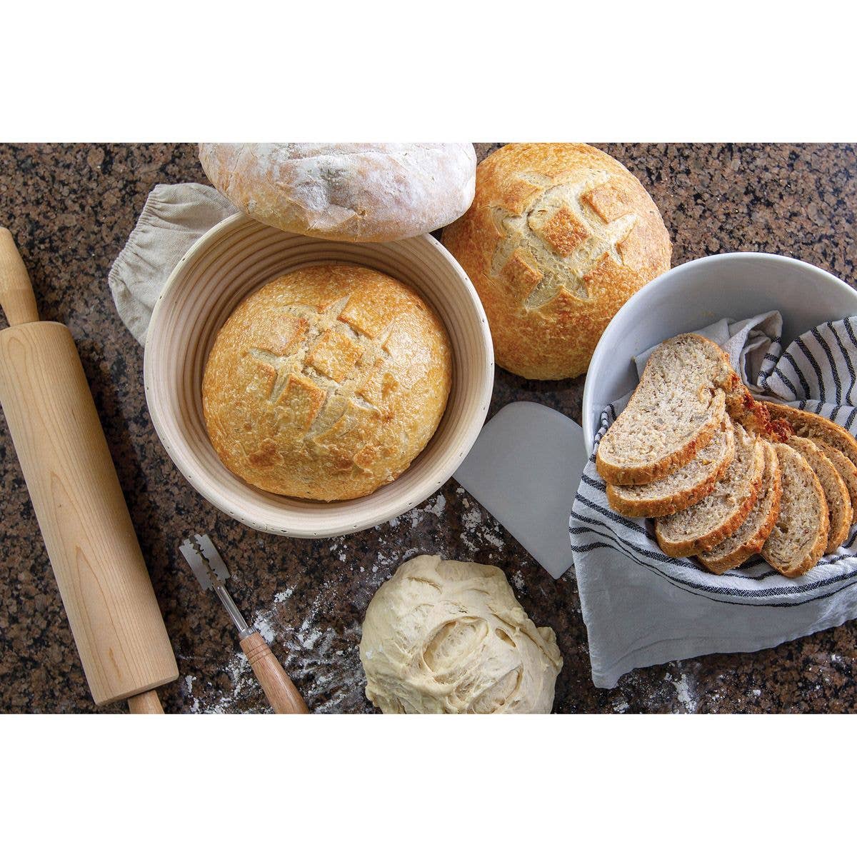 Baked bread items including loaves and slices on a countertop with a rolling pin and knife.