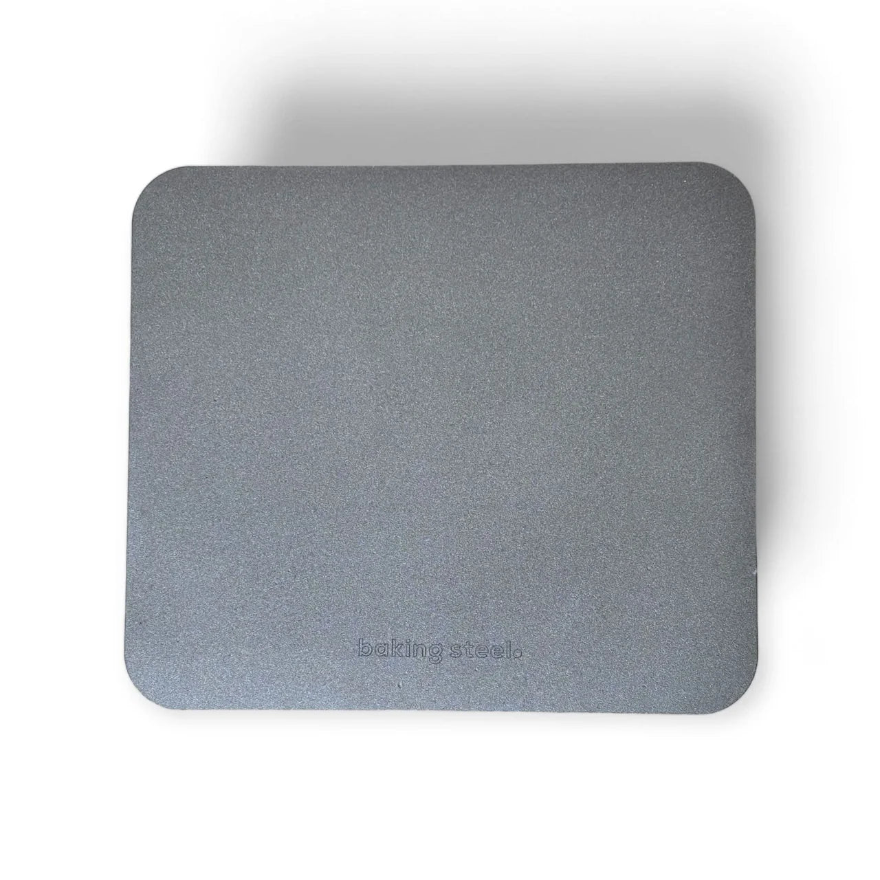 A rectangular gray carbon baking steel with rounded corners and the debossed brand name 'baking steels' near the bottom, shown on a white background with a soft drop shadow.