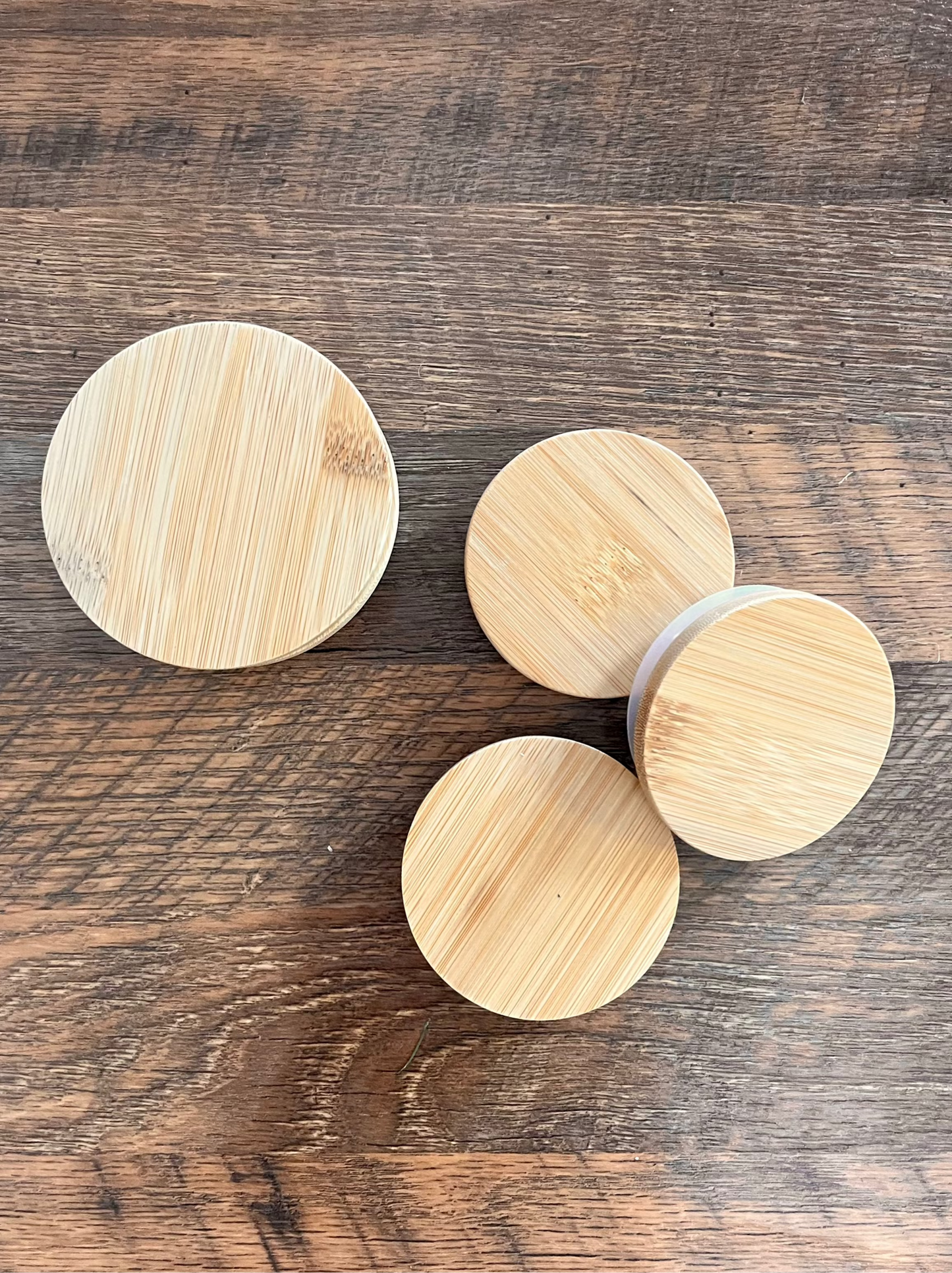 Four bamboo lids on a wooden surface