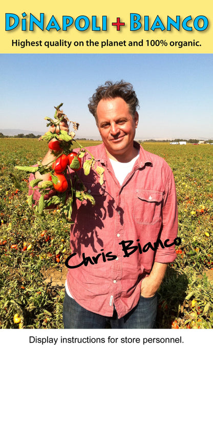 Chris Bianco holding a bunch of tomatoes in an organic field.