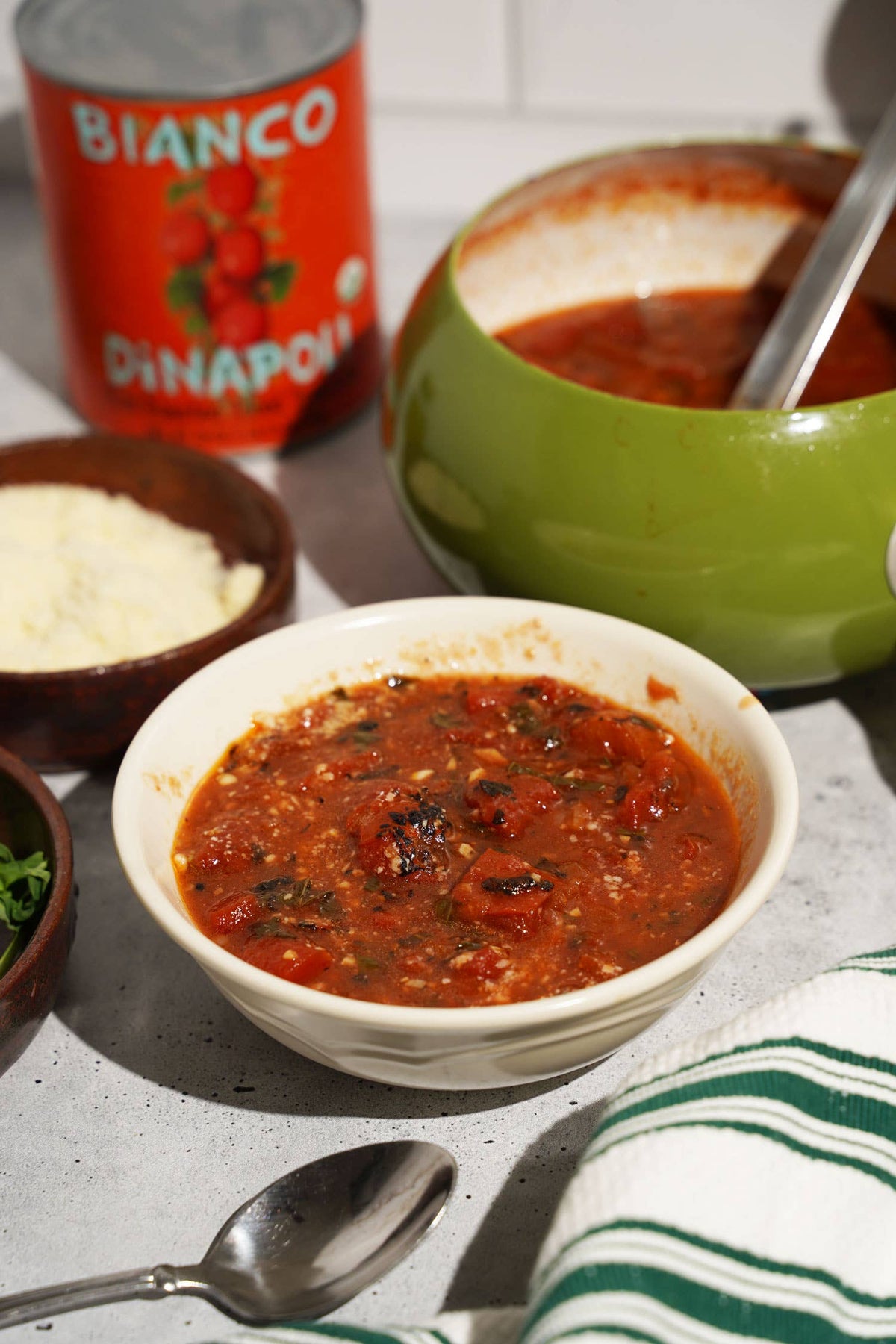 Bowl of Fire Roasted Tomatoes with a Bianco DiNapoli can and cheese in the background