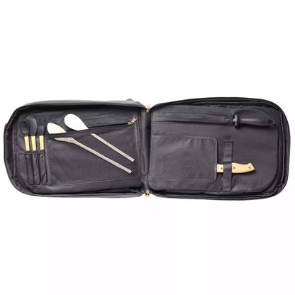 An open black nylon carrying case displaying its interior organization, which holds multiple stainless steel tools and utensils including spatulas, skewers, and a knife with a light wood handle.