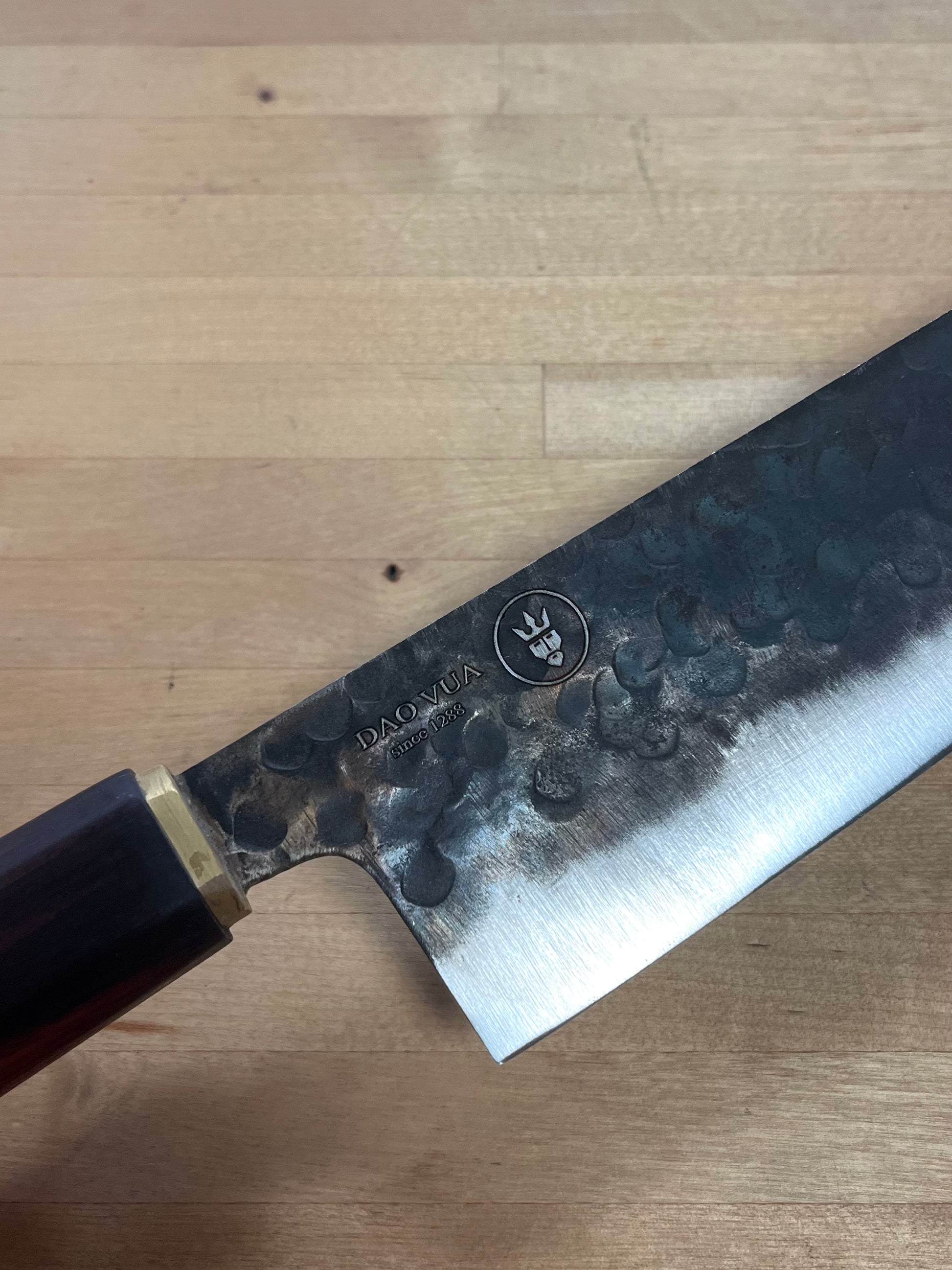 Dao Vua knife with a maker's mark brand on a cutting board