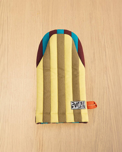 Multicolored striped pouch with a brand tag on a wooden surface