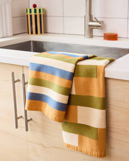 Colorful striped towel hanging on a kitchen cabinet handle