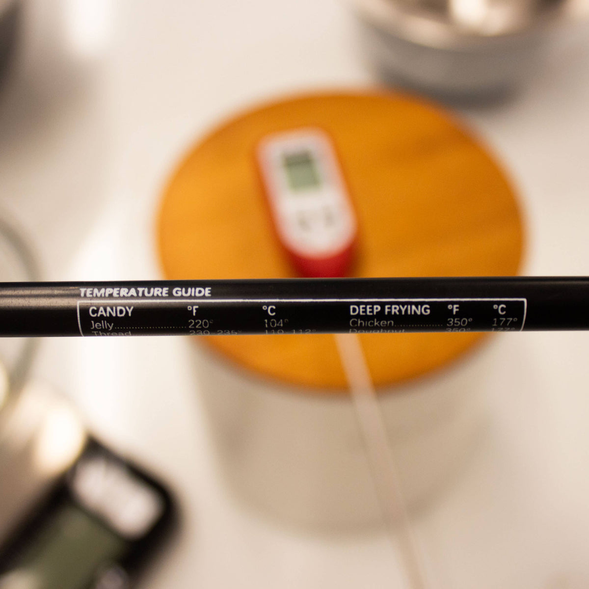 Temperature guide stick with digital thermometer on a blurred kitchen background