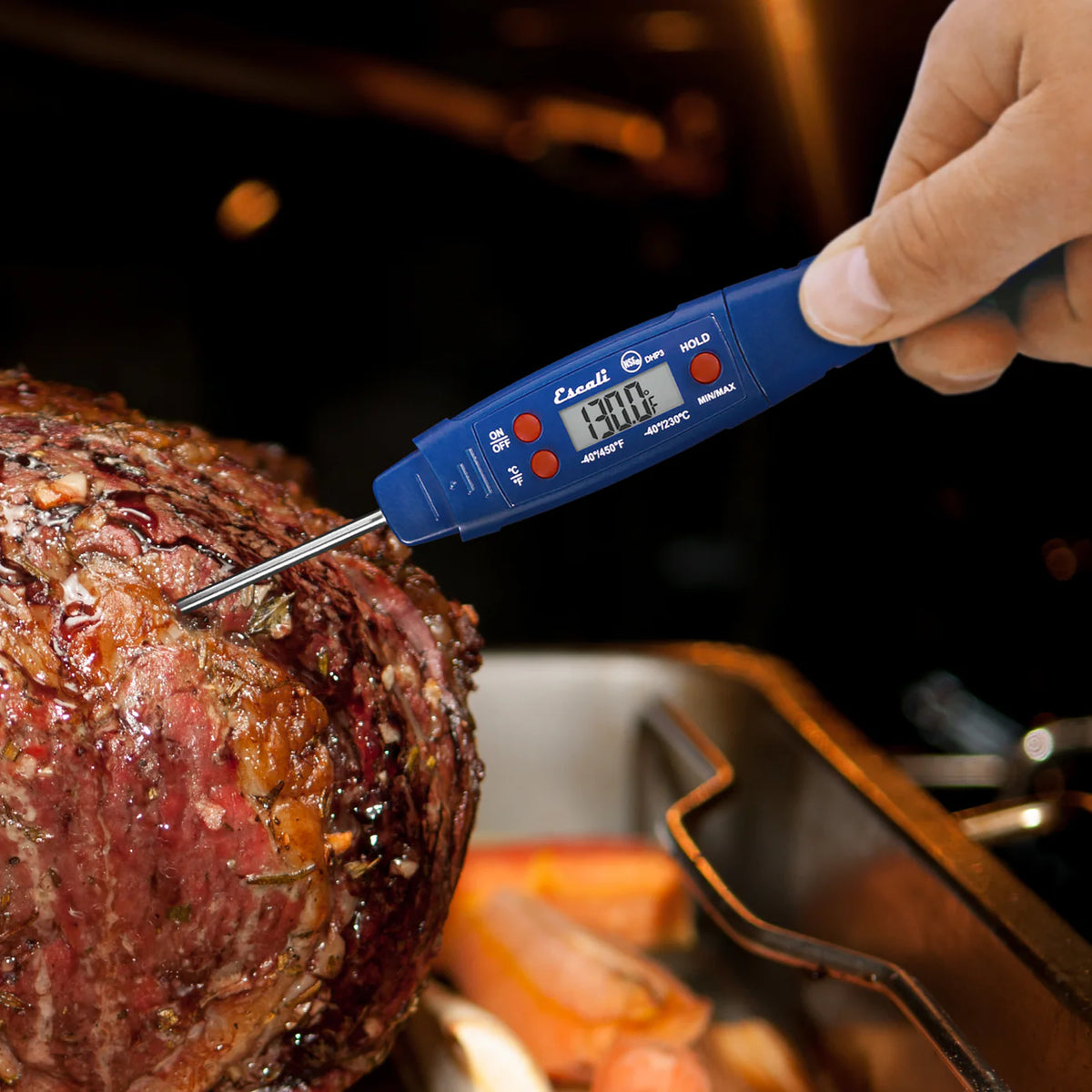 Digital thermometer inserted into a roasted meat on a grill