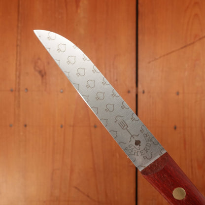 Knife with a red handle and engraved blade on a wooden background
