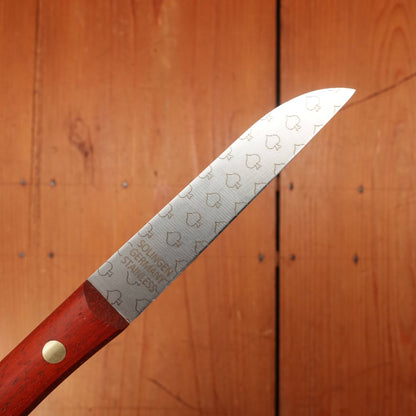 Knife with a red handle and engraved blade on a wooden background