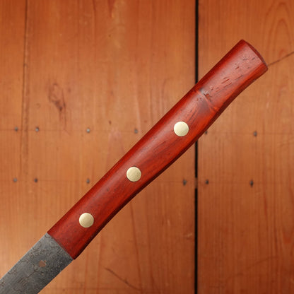Wooden-handled knife with three metal rivets against a wooden background