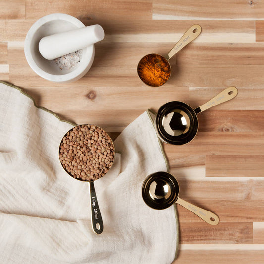 Measuring cups with ingredients on a wooden surface