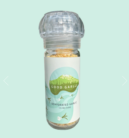 Bottle of dehydrated garlic with a 'Good Garlic' label on a light blue background
