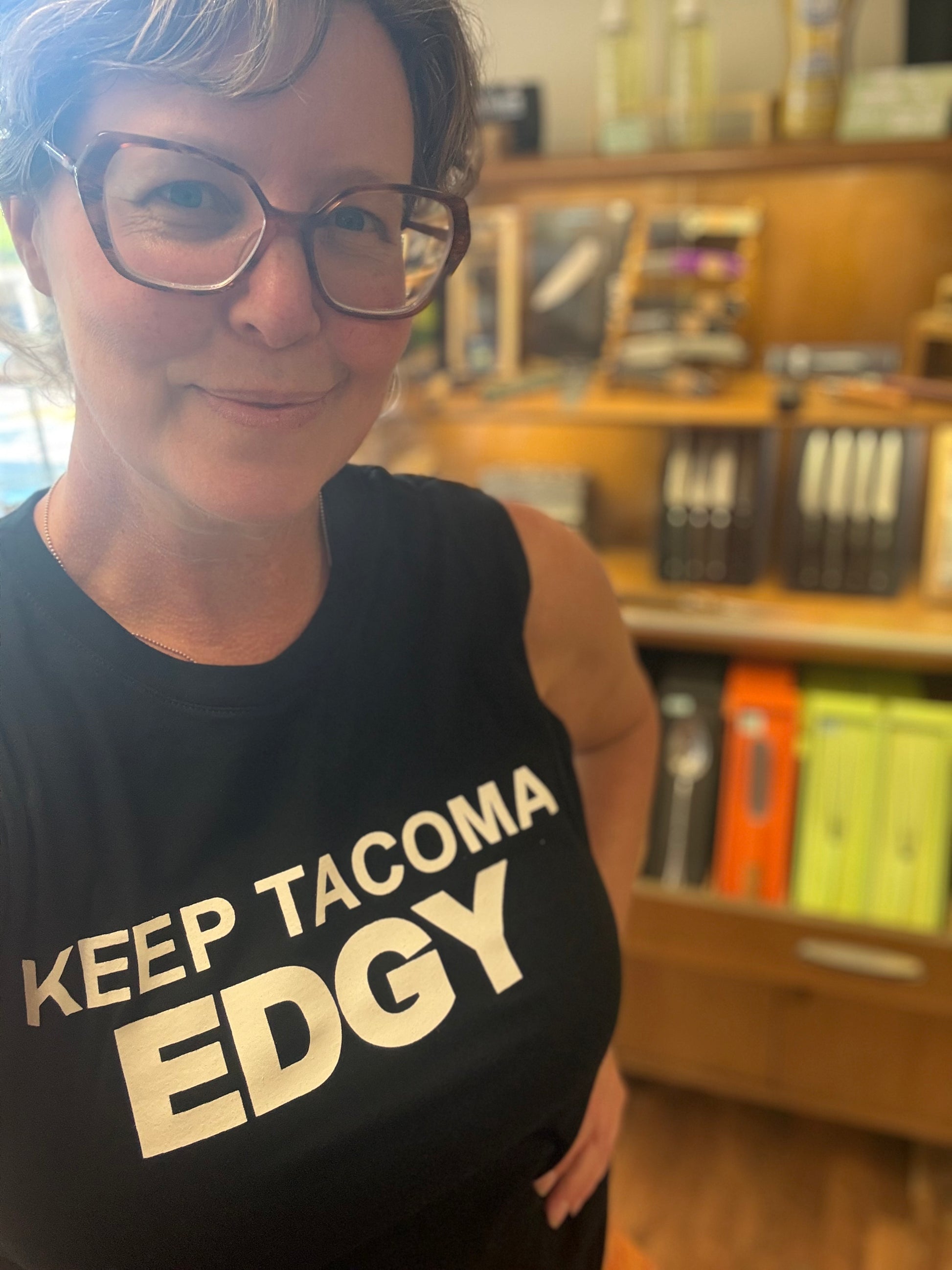 Sarah wearing a black 'KEEP TACOMA EDGY' muscle tee.