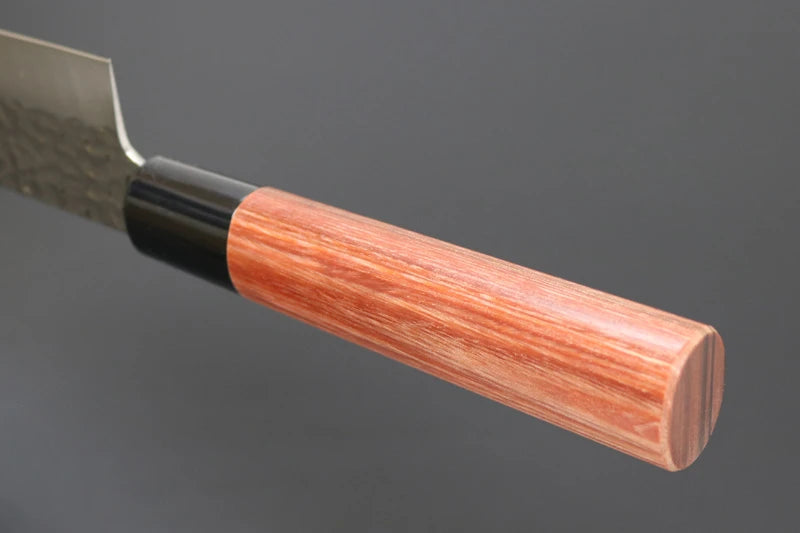 A close-up of a Japanese kitchen knife showing its wooden handle and textured steel blade against a dark gray background.