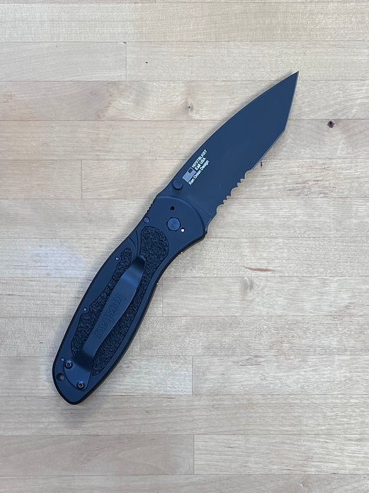 Black folding knife on a wooden surface