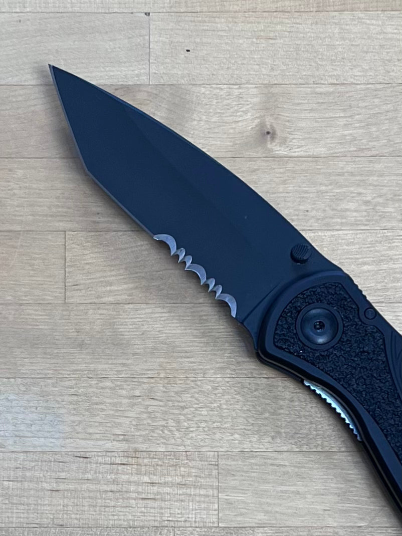 Blur tanto blade with serrations on wood cutting board.