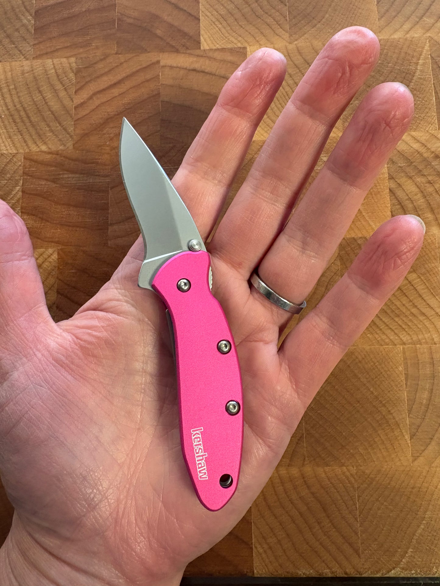 pink Kershaw pocket knife in hand, showing its smaller size