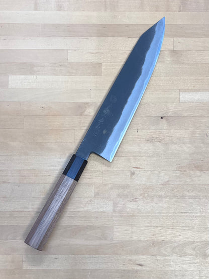 Chef's knife with a wooden handle on a wooden surface