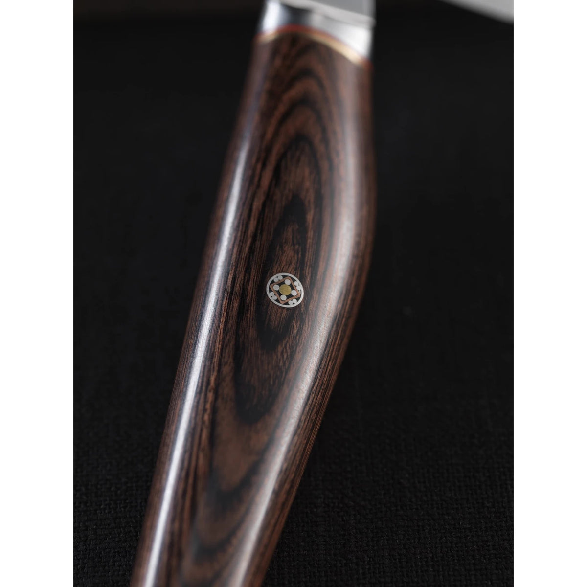 Close up of rosewood knife handle with mosaic pin on  back background