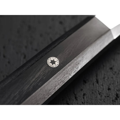 Mosaic pin on black wooden knife handle on black textured background.