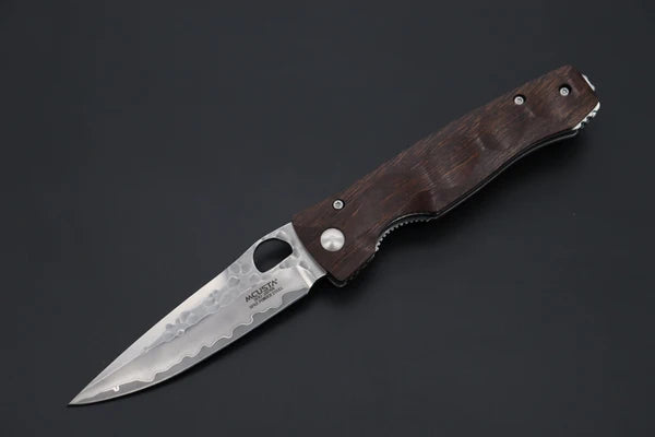 A folding pocket knife with a dark brown wooden handle and a silver steel blade, shown open against a dark gray background. The blade features a visible 'MCUSTAl' logo.