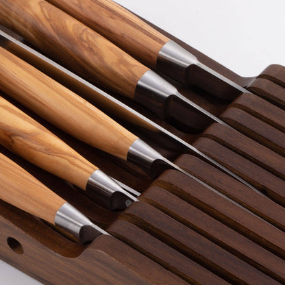 Set of knives with wooden handles and metal blades  in wood holder on a white background