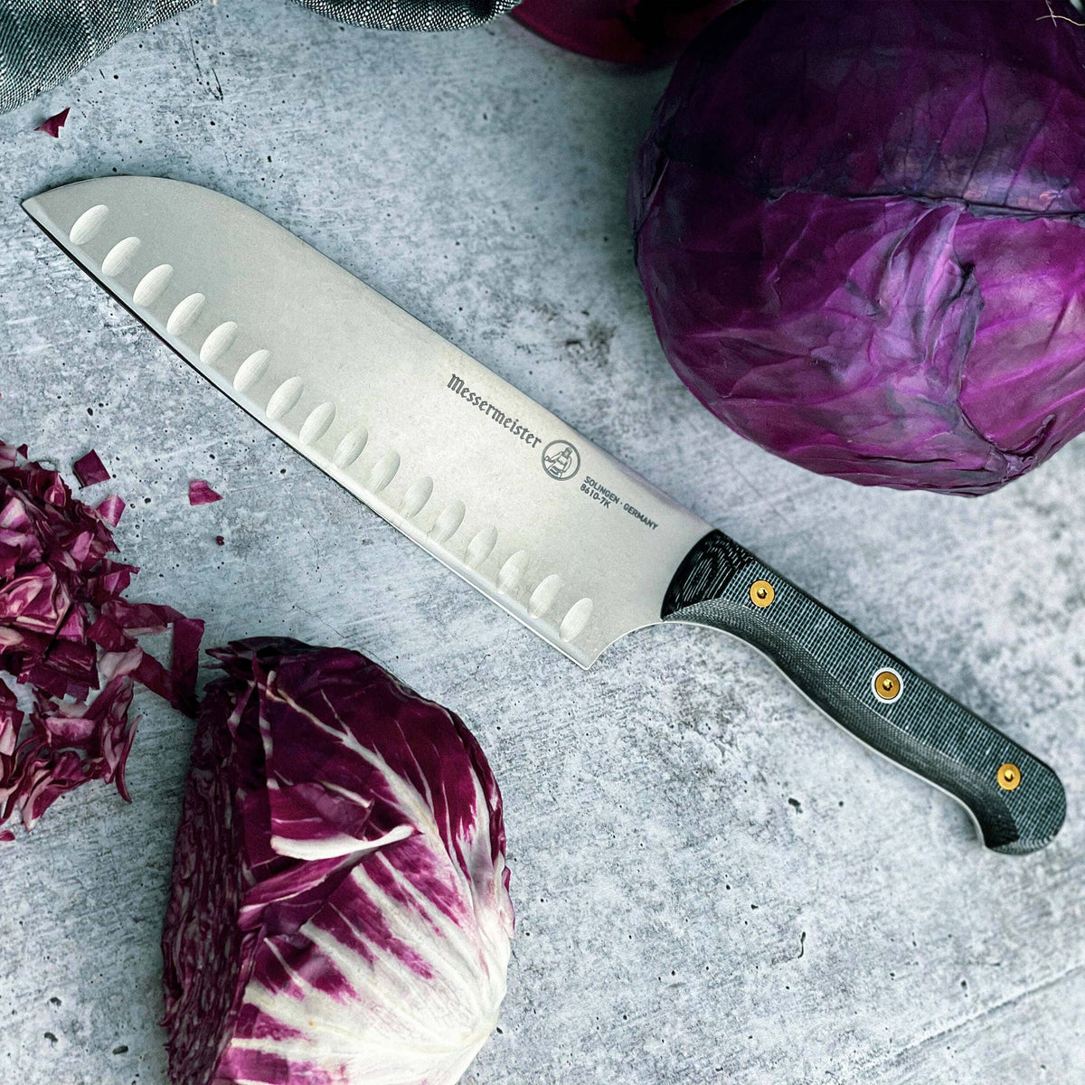 Messermeister Custom Santoku on grey surface with purple cabbage