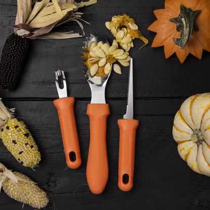 Three orange-handled tools on a dark surface with pumpkins and corn ears.