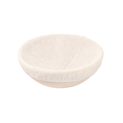 Round proofing basket with a white fabric liner on a white background