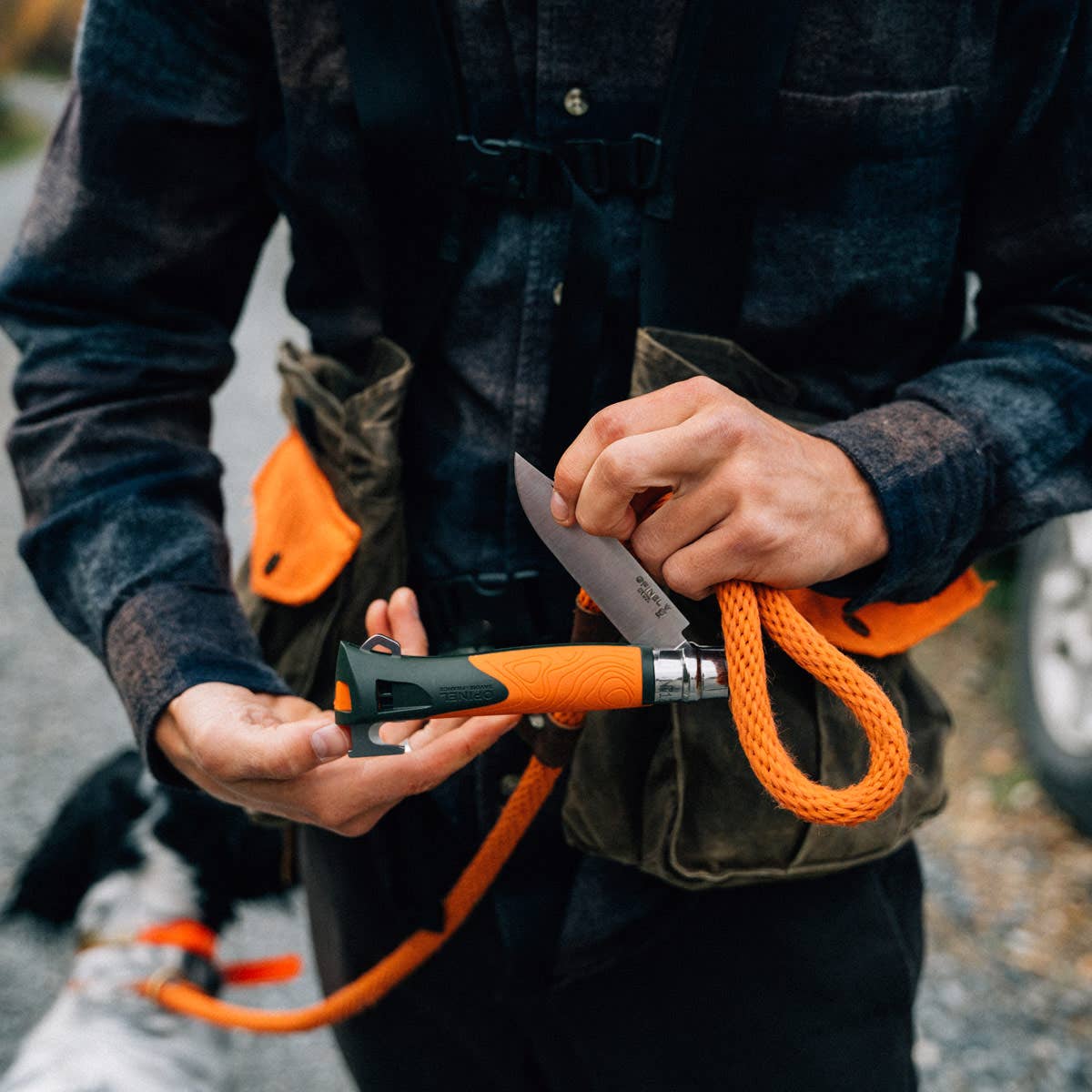 An outdoors person holding an Orange Opinel No. 12 Explore knife.