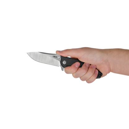 A hand holding a folding pocket knife with a satin-finished silver blade and a textured black handle, shown against a plain white background.